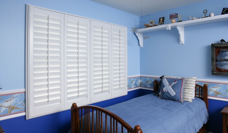 White plantation shutters in blue kids bedroom in Austin 